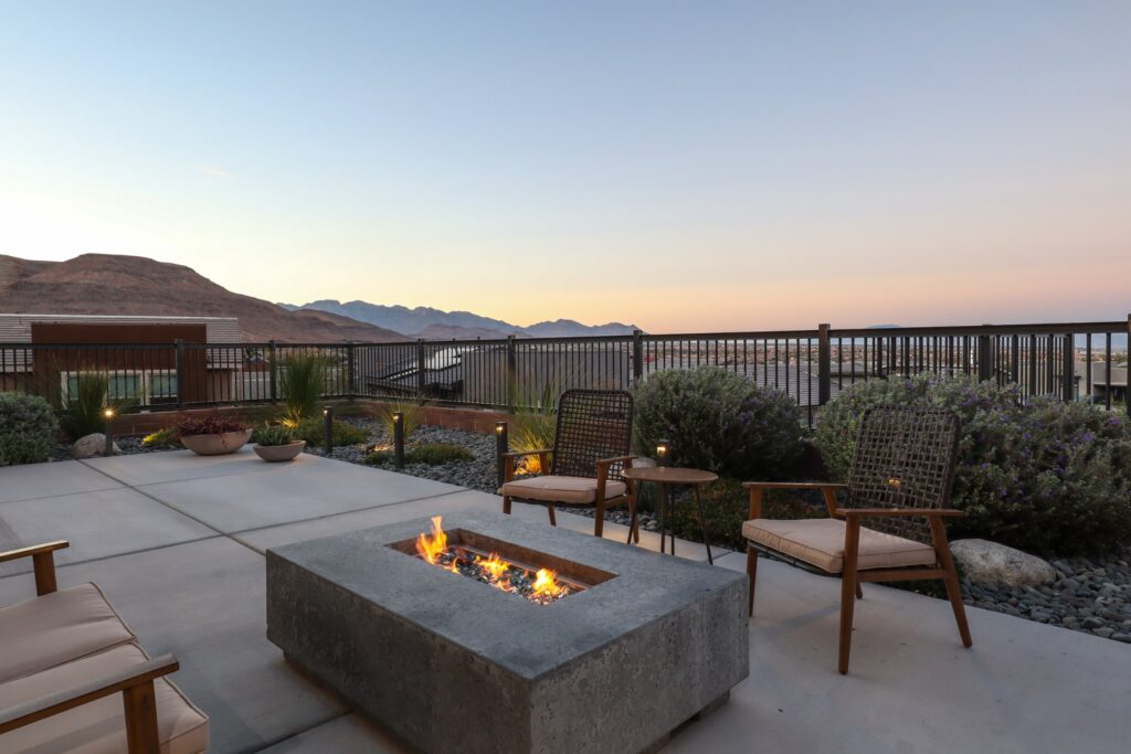 Patio with a fire pit and mountain view at sunset